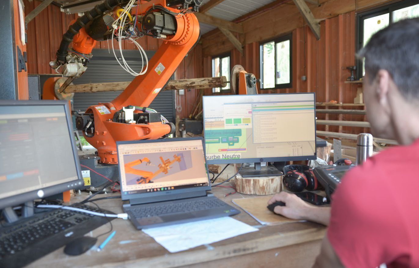 KUKA robotic arm cutting a curved log with a chainsaw attachment in the workshop